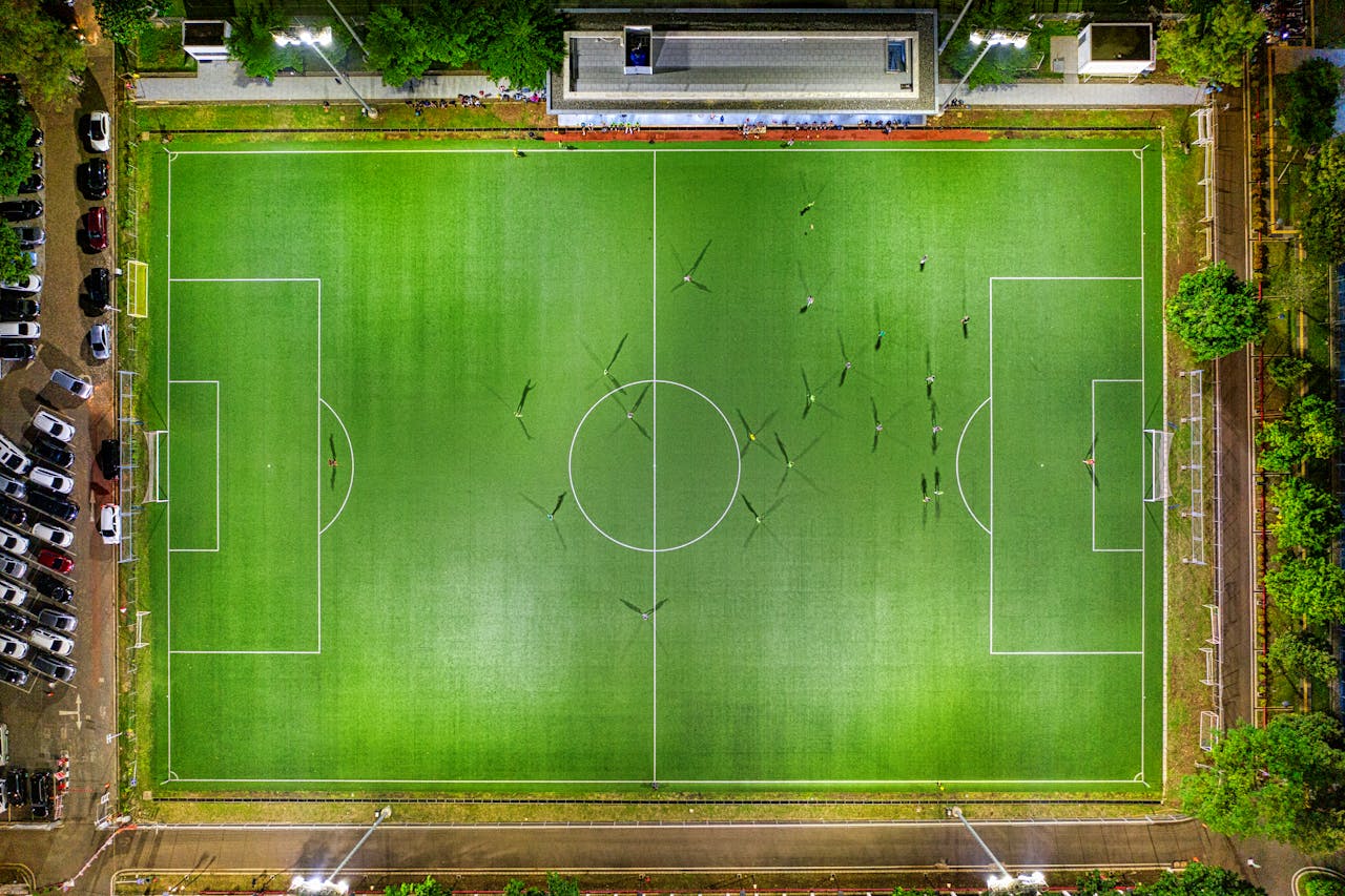 Stunning aerial view of a soccer field in Jakarta, Indonesia at night with players in action.